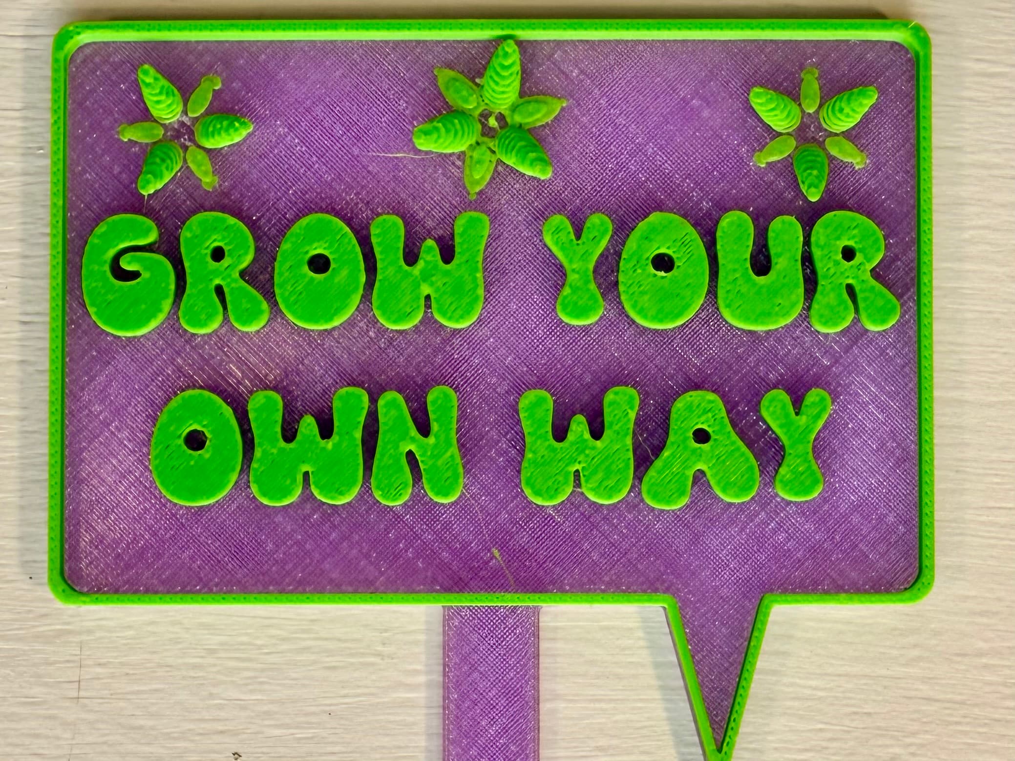 3D-printed pot pick with raised text reading 'Grow Your Own Way'