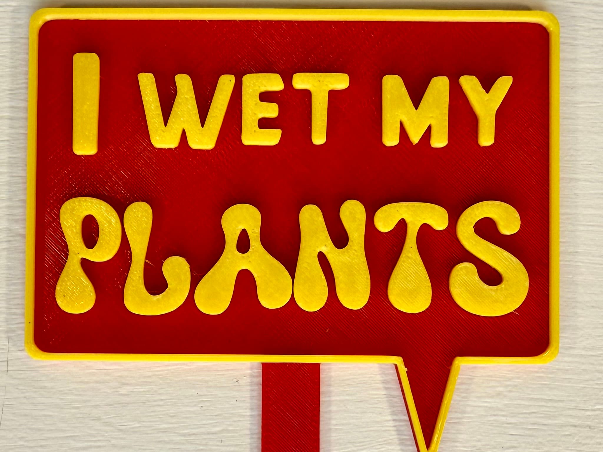 3D-printed pot pick with raised text reading 'I Wet My Plants'