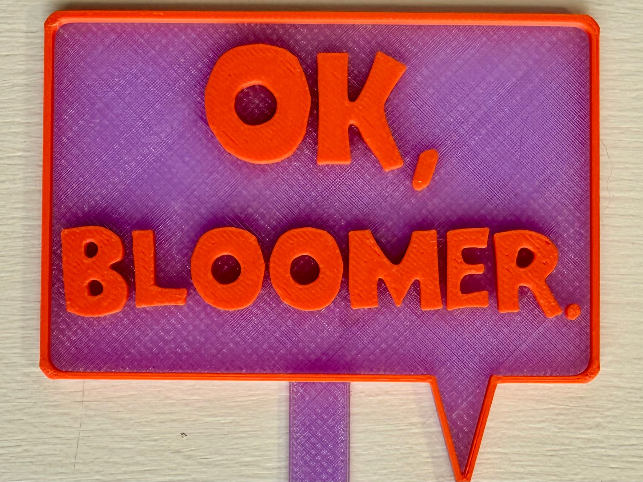 3D-printed pot pick with raised text reading 'Ok Bloomer'
