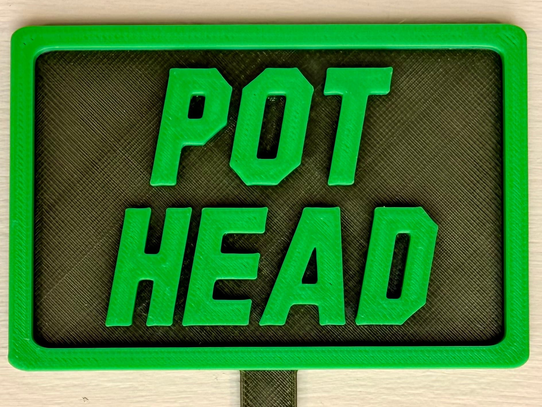 3D-printed pot pick with raised text reading 'Pot Head'