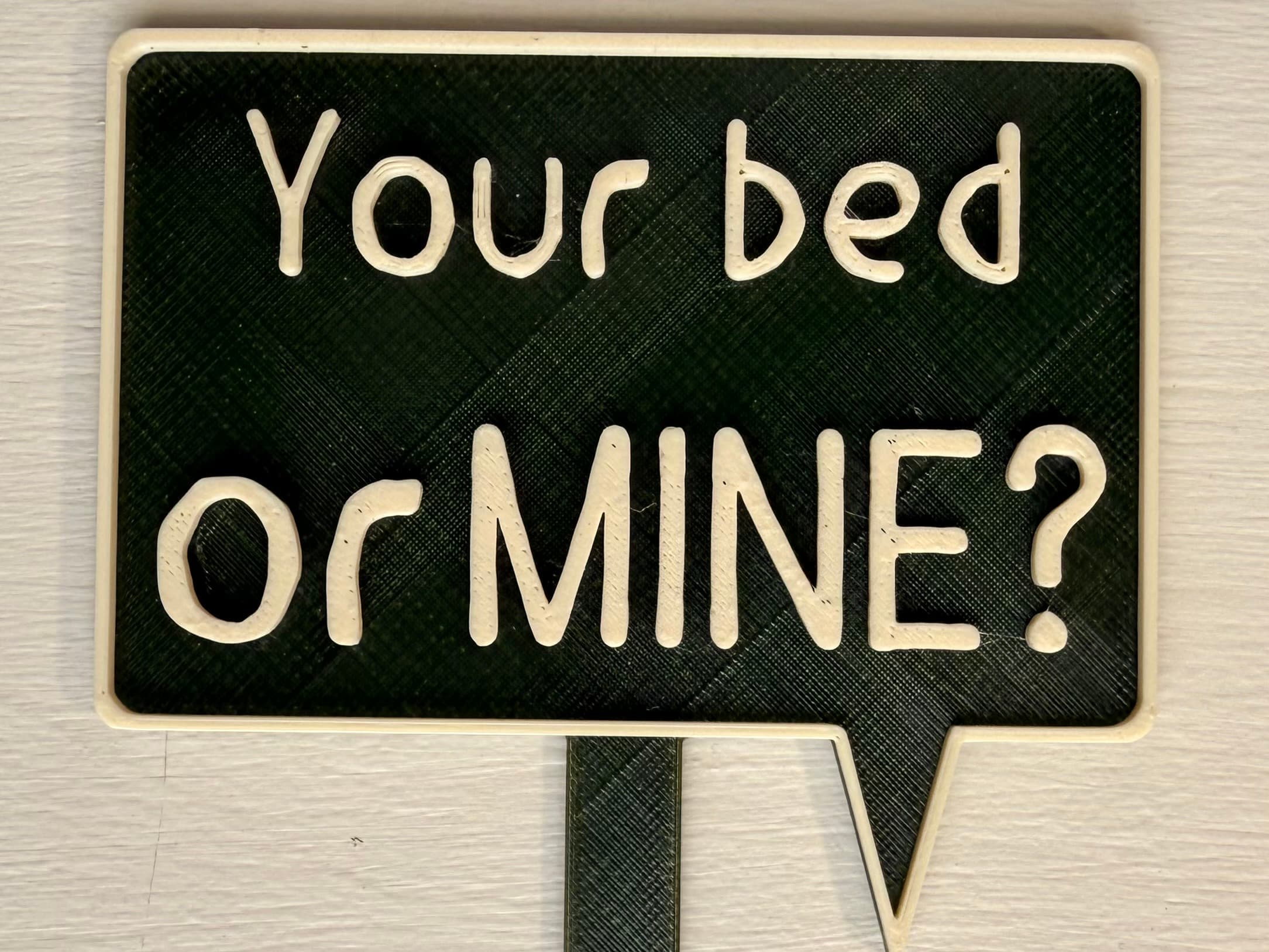 3D-printed pot pick with raised text reading 'Your Bed or Mine?'